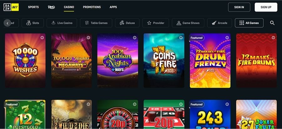 DAZN Bet UK casino landing page featuring a dark, premium interface with sports and casino navigation. The game grid displays a "Featured" section with popular slots including 12 Masks of Fire Drum Frenzy Epic Strike, 10,001 Nights Megaways, and 10,000 Wishes. Category filters highlight Slots, Live Casino, Table Games, and Game Shows. Branded in black and yellow with clear "Sign In" and "Sign Up" options.